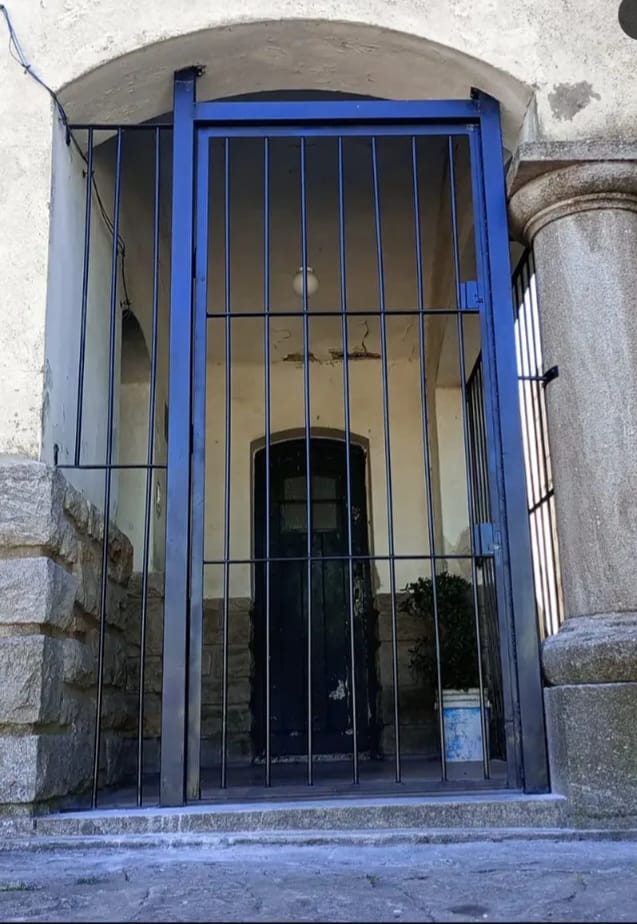 Cerramiento de acceso azul con barras verticales en arco de piedra — Mar del Plata